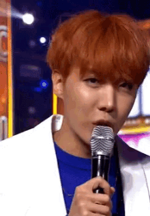 a man with red hair is holding a microphone in his mouth
