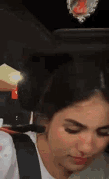 a woman is sitting in the back seat of a car looking down .