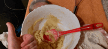 a person giving a thumbs up in front of a bowl of dough
