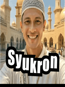 a man wearing a hat is smiling in front of a building with the word syukron written on it