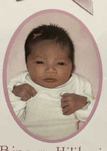 a picture of a baby in a pink oval with the letter h on the bottom