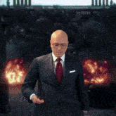a bald man in a suit and tie adjusts his collar