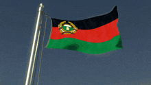 the flag of afghanistan is waving in the wind with a blue sky in the background