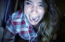 a woman wearing headphones is making a funny face while looking at the camera .