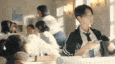 a girl in a tie looks at her phone while sitting in a classroom