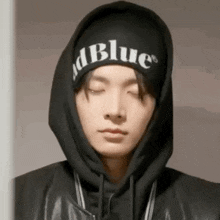 a close up of a person wearing a hoodie and a hat .