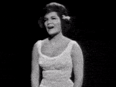 a black and white photo of a woman in a white dress with her arms outstretched