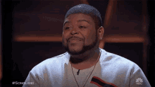 a man with a beard wearing a nbc sweatshirt