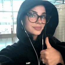 a woman wearing glasses and a black hoodie with the word toesign on it