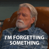 an older man sitting in a chair with the words i 'm forgetting something written below him