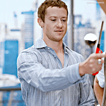 a man in a blue striped shirt is holding a pair of scissors and the caption joechinncraves