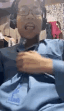 a person wearing headphones and a blue shirt is holding a piece of paper .