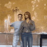 a man and a woman are dancing in a room with a yellow wall