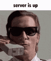 a man wearing sunglasses is talking on a telephone with the words server is up above him
