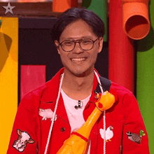 a man in a red jacket with a cow and chicken embroidered on the sleeves