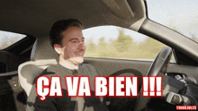 a man driving a car with the words ca va bien written on the bottom