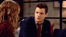 a man in a suit and tie is talking to a woman in a leopard print shirt