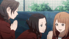 a group of anime girls are standing next to each other and one of them is praying