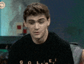 a man wearing a black shirt that says golden
