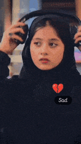 a woman talking on a cell phone with a broken heart on her face