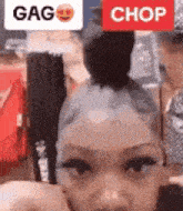 a close up of a woman 's face with a bun in her hair and a sign that says `` chop '' .