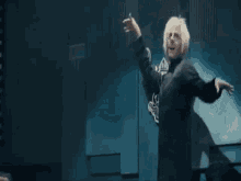 a woman with blonde hair is dancing on a stage in a dark room .