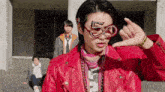 a man wearing a red leather jacket and glasses with the number 50 on them