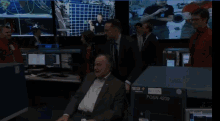 a man in a suit sits in front of a posn 4200
