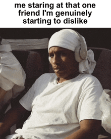 a man wearing headphones is sitting in a chair with the caption me staring at that one friend i 'm genuinely