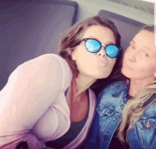 two women wearing sunglasses are posing for a picture together