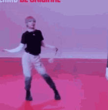 a person is walking on a red floor while holding a tennis racket .