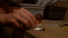 a man is sniffing a piece of cocaine on a table next to a warning sign