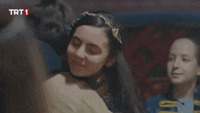 a tv screen shows a girl hugging another girl with trt1 written on it