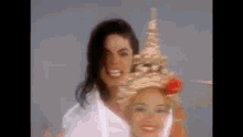 a man and a woman are standing next to each other and smiling . the woman is wearing a traditional thai hat .