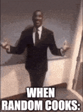 a man in a suit and tie is standing with his arms outstretched in a hallway .