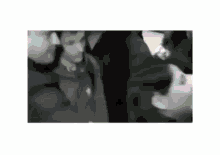a black and white photo of a group of people standing next to each other in a crowd .