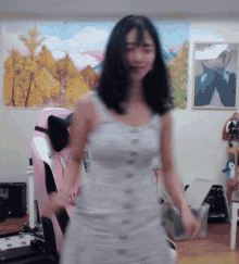 a woman in a white dress is dancing in front of a pink chair that says meb