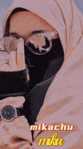 a woman wearing a hijab and sunglasses with the name mikachu on the bottom right