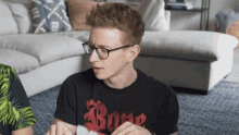 a man wearing glasses and a black t-shirt with the word bone on it