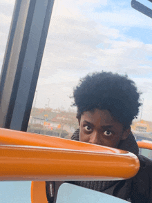 a person wearing a eastpak scarf looks out of a window