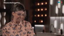 a woman wearing glasses and a shirt that says ' masterchef argentina ' on the bottom
