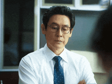 a man wearing glasses and a white shirt and tie