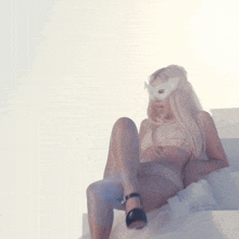 a woman wearing a white mask is sitting on a bed