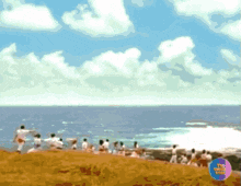 a group of people standing on top of a hill overlooking the ocean with a circle in the corner that says tv news today