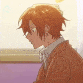 a boy with orange hair is sitting in front of a window wearing glasses .