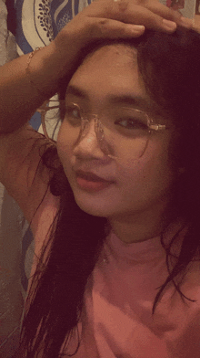 a young girl wearing glasses and a pink shirt