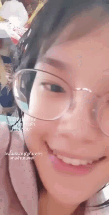a woman wearing glasses is smiling for the camera .