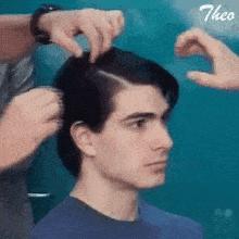 a man is getting his hair cut by a hairdresser in a hair salon .