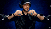 a man wearing headphones and a black hat is holding a blue ball in his hands