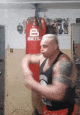 a man is standing in front of a red bag that has the letter b on it